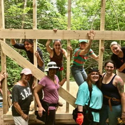 women carpenters building a structure raising a wall