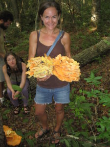 happy forager with giant chicken of the woods mushrooms