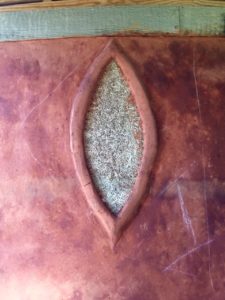 red natural DIY paint on an earthen wall with sculpted accent