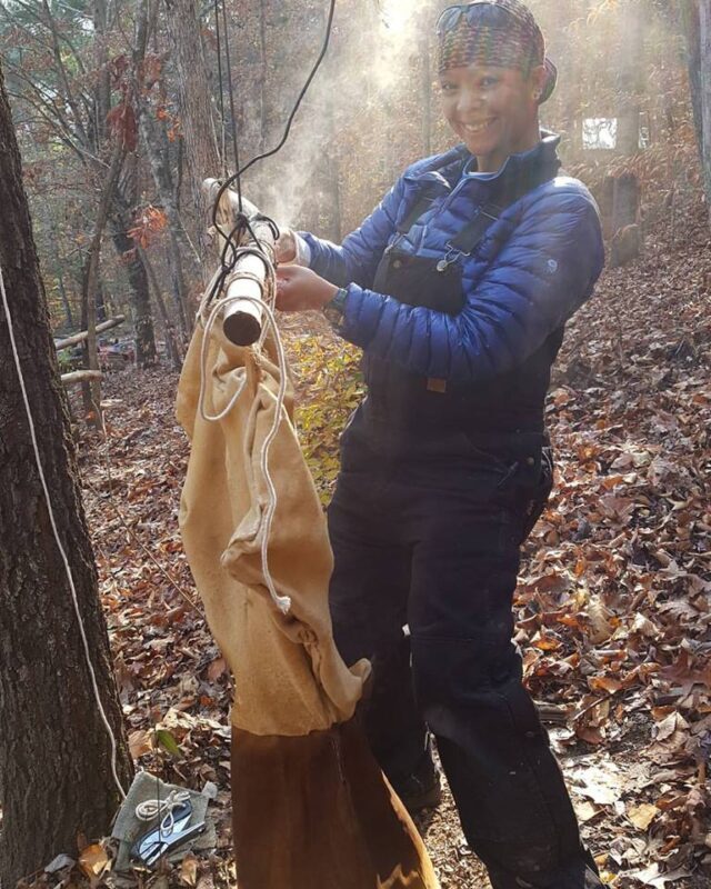 woman smoking a deer hide during brain tanning