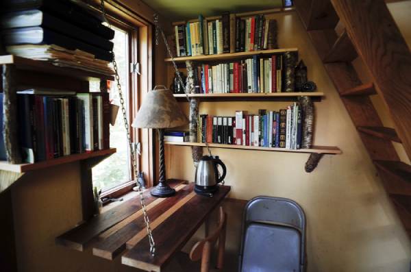 space efficient bookshelves and desk and ladder in tiny house