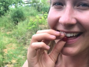 woman smiling putting a gooumi berry in her mouth