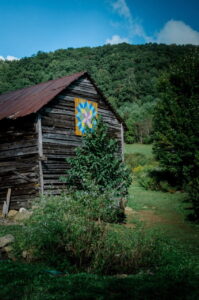 tall barn with painted design and green mountain