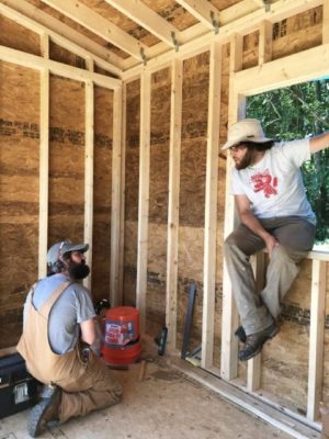 men talking and building a tiny house