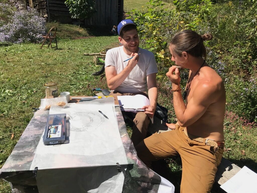 Two men at a picnic table with a map splitting up a tract of land