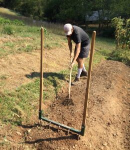 volunteering on a local farm hoeing a garden bed