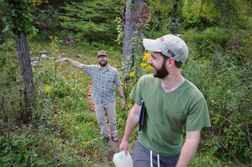 Two men in a gardening one pointing and teaching