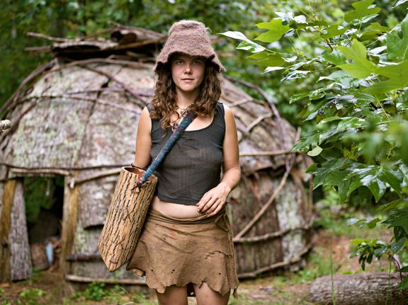 natalie bogwalker in front of a tulip poplar bark hut at the Wild Roots earthskills Community
