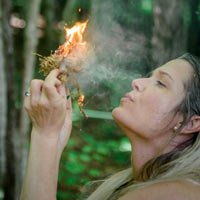 Woman blowing on a tinder bundle on fire