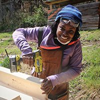 woman using a speed square to do carpentry