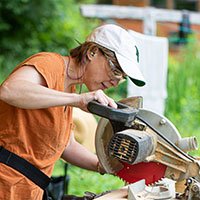 woman using a speed square to do carpentry