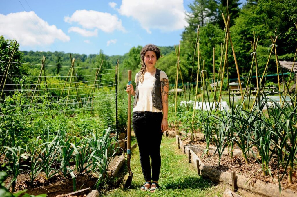 woman standing in garden with shovel