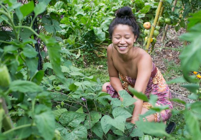 Young woman examining plants in a garden