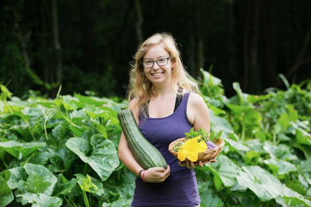 woman in garden with huge zucchini