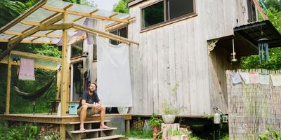 tiny house builder in front of his tiny house on wheels