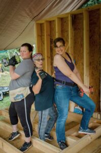 three women with tools doing carpentry