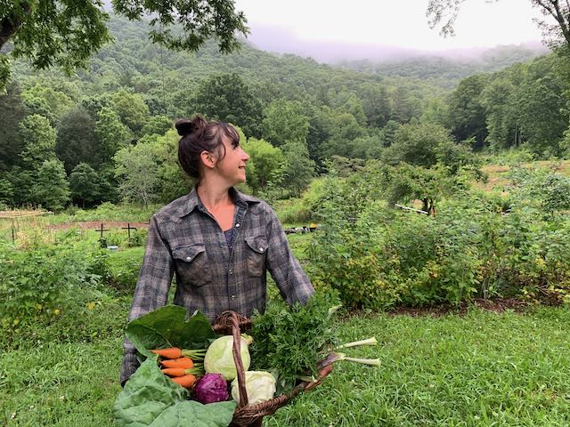 woman holding basket of fall vegetables