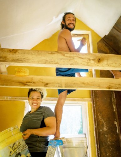 building students using earthen paint in tiny house