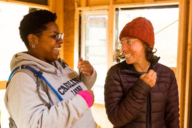 Two students laugh together during tiny house workshop