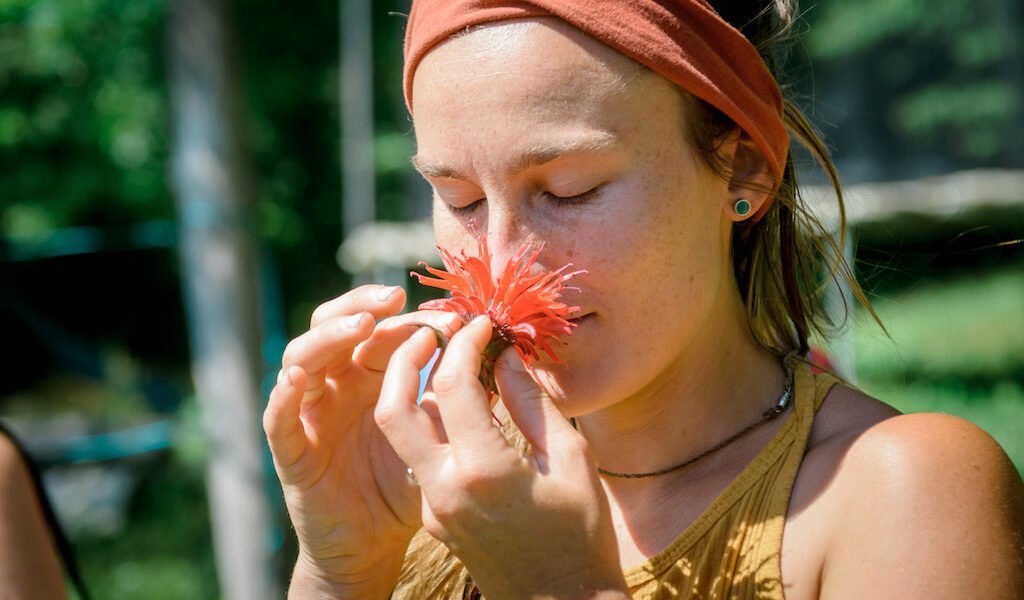 Student smelling flower during women's rewilding class