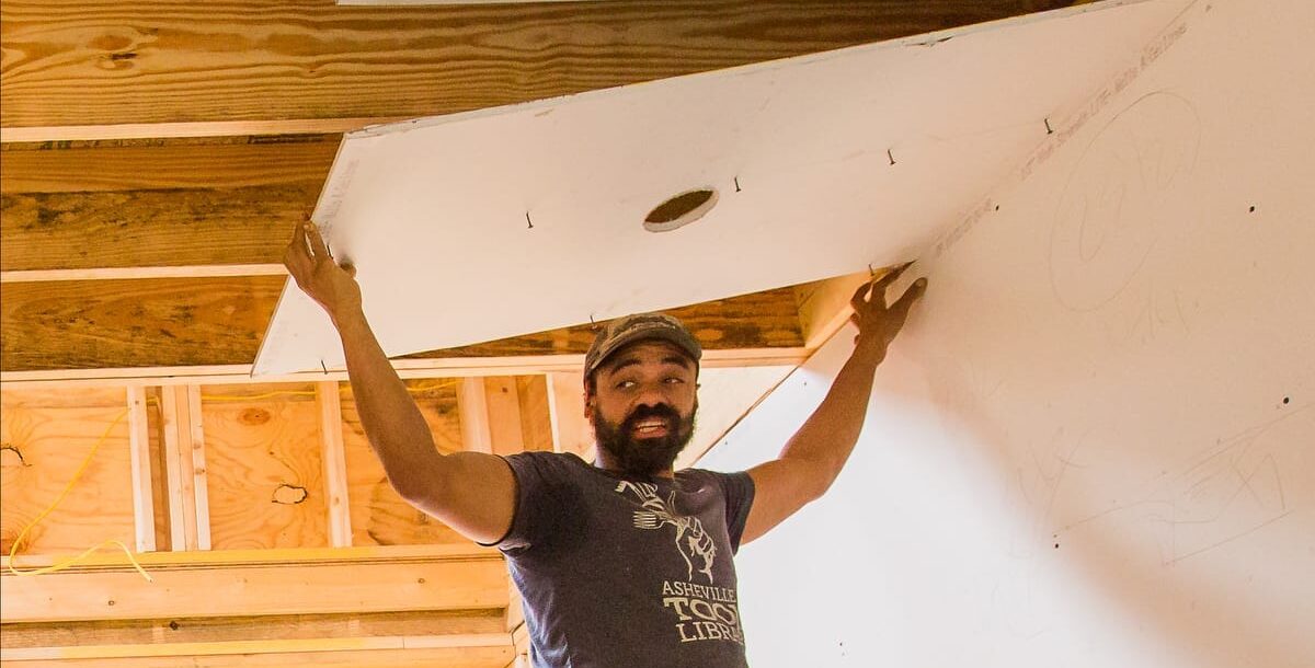 ABC-1200-cropped-2024-updated-234 Instructor Keenan Thompson demonstrating how to install drywall on a ceiling of a DIY Tiny House constructed during a Wild Abundance Workshop