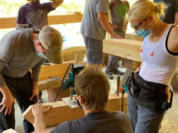 timber framing class students using power tools to make mortises