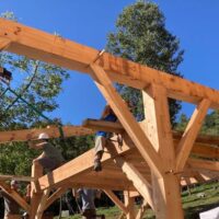 Students work on top of frame during timber framing class