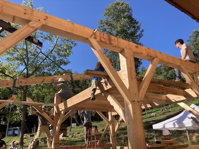 Students sitting on top of timber framed structure during timber framing class