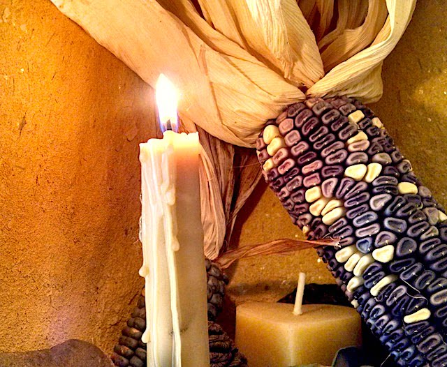 Beeswax candle with corn on an altar during rewilding class
