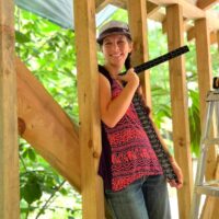 Woman poses with t-square during women's advanced carpentry class