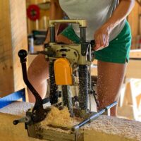 Student uses machine during timber framing class