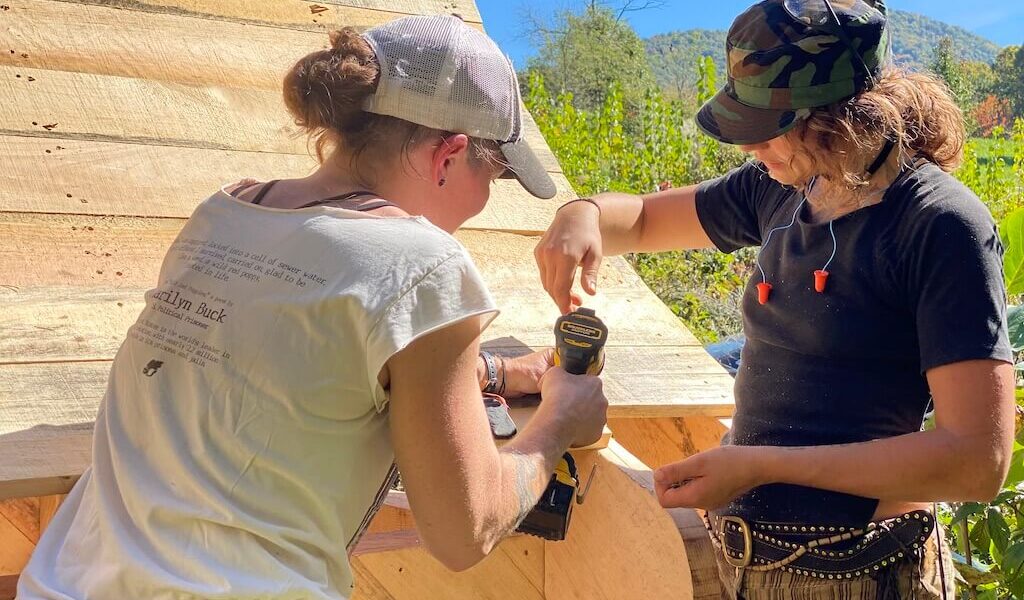 Two women work together during women's advanced carpentry class