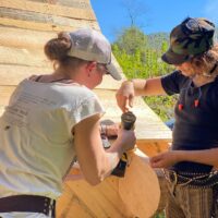 Two women work together during women's advanced carpentry class