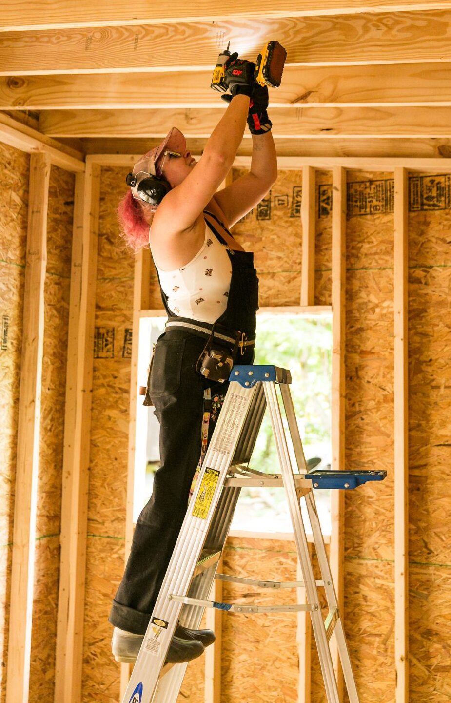 woman in front of tiny house with natural plaster
