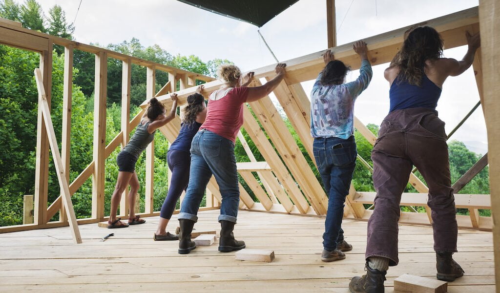 Five women raise wall during tiny house workshop
