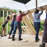 Five women raise wall during tiny house workshop