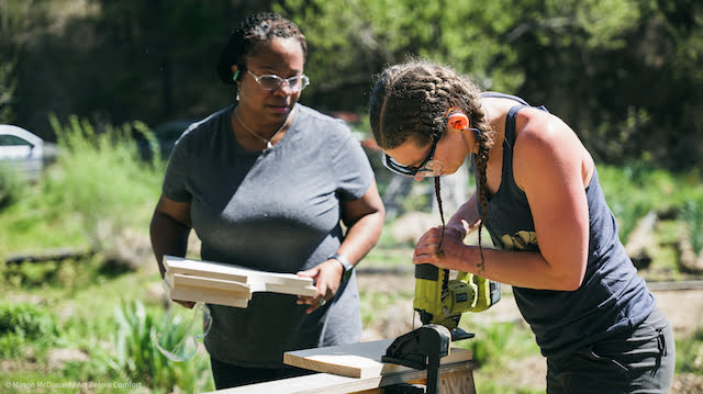 Women using jigsaw to build tiny house