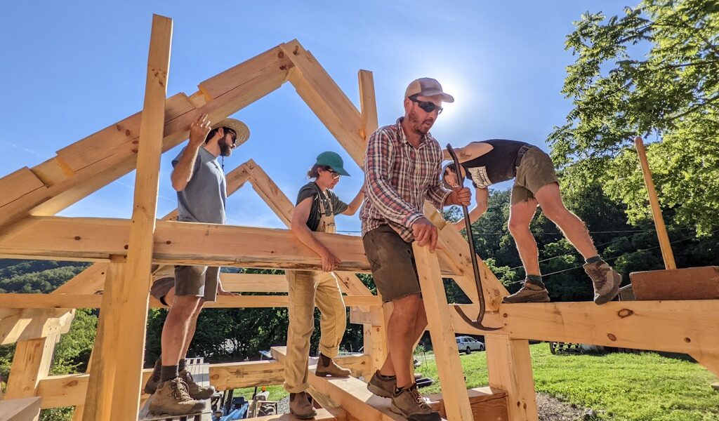 a timber frame structure is being constructed during a wild abundance building workshop