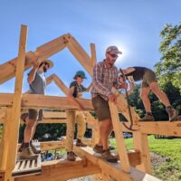 a timber frame structure is being constructed during a wild abundance building workshop