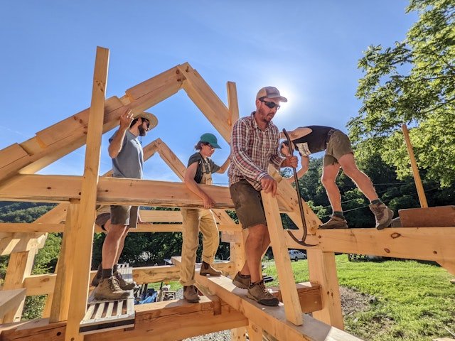 An instructor leads a group of students on a build during a Timber Frame Building Workshop hosted by Wild Abundance