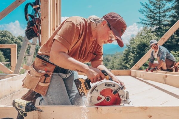 person using a cordless circular saw to help build a tiny house
