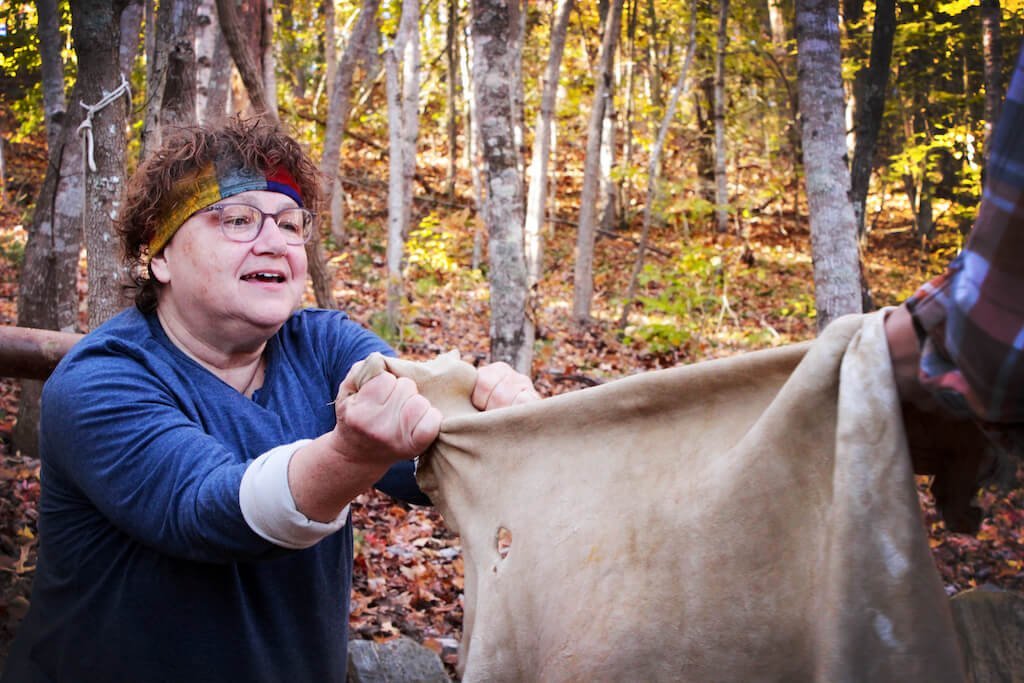 Student stretching buckskin during hide tanning class