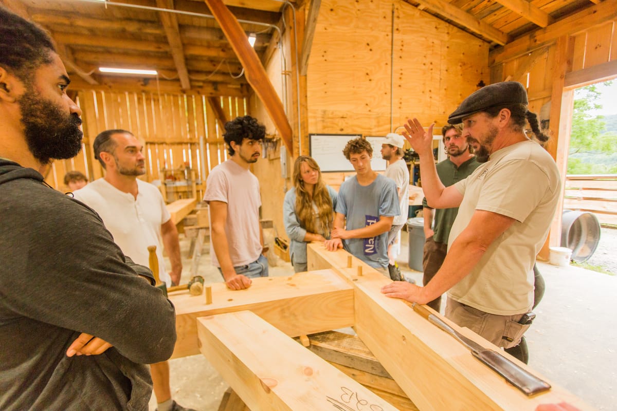 TF-1200-2025-88 Students learn from professional Timber Framers inside a real workshop during a Wild Abundance Workshop