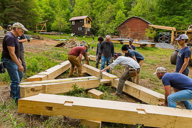 Students putting a timber frame bent together before raising it during a Timber Framing Workshop as they build a structure at Wild Abundance.