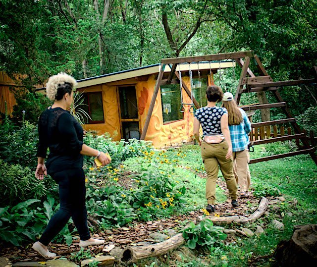 Tiny house students walking on tour to earthen paint adobe tiny home