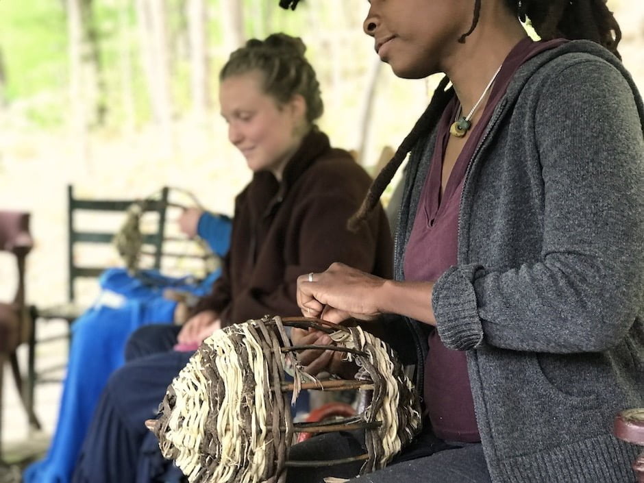 Two women weaving baskets during Rewilding Weekend