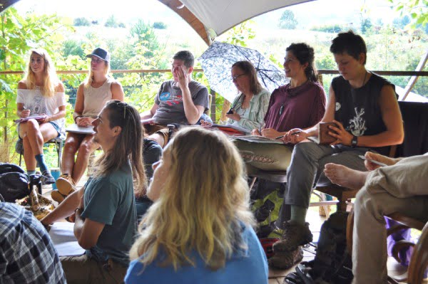 permaculture design certificate students sitting in an outdoor classroom