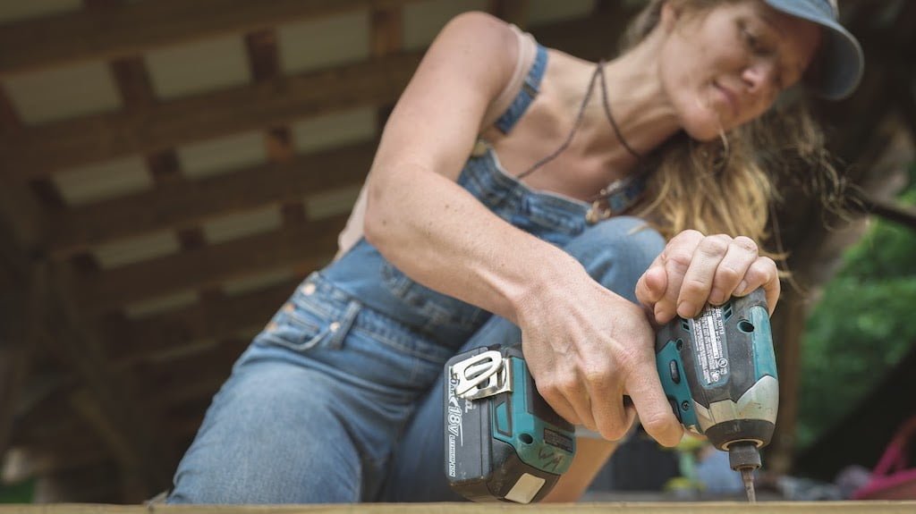 Woman uses drill to build tiny house
