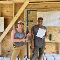 Two instructors laugh together during Tiny House class
