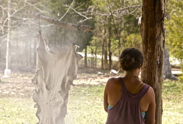 A woman smokes a hide for deer tanning class